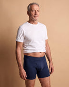 Uomo con il boxer assorbente LUIDRY™ blu navy e una t-shirt bianca