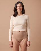 Donna con lo slip assorbente LEIDRY™ Giorno beige a vita alta e maglia color panna