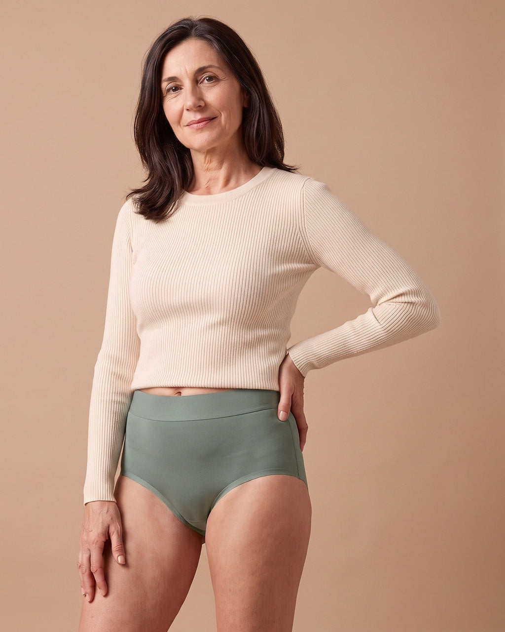 Donna con lo slip assorbente LEIDRY™ Giorno verde salvia a vita alta e maglia color panna
