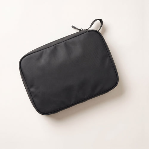 Pochette da viaggio LEIDRY™ che esce da una borsa, con uno slip di ricambio dentro