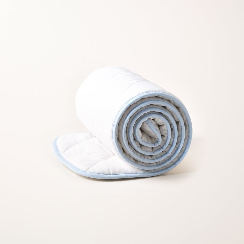 Traversa lavabile LEIDRY™ 70×90 arrotolata: lato morbido trapuntato e retro impermeabile, su fondo bianco